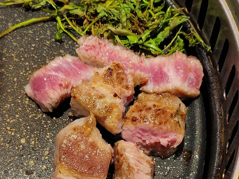 잘 구워진 오겹살과 곁들임 채소