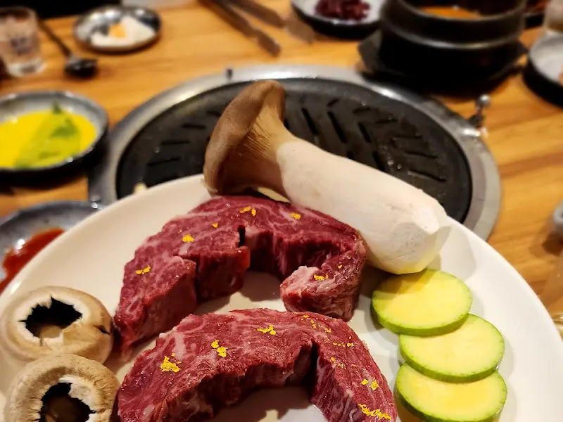 불판 옆에 놓인 한우와 버섯