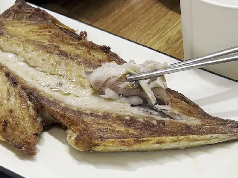 고등어구이의 살을 발라 밥 위에 얹어 먹는 모습