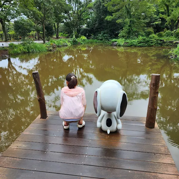 호숫가에 앉아 있는 소녀와 스누피 조형물