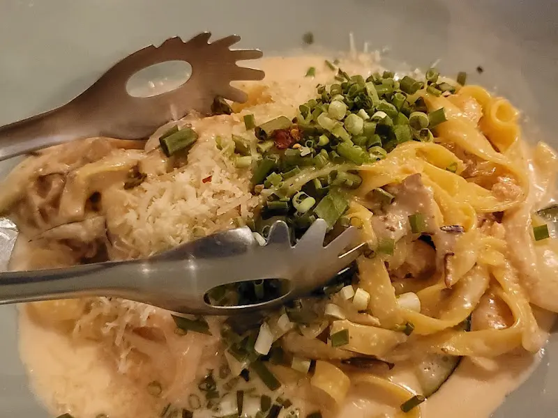 맛있는 파스타 위에 신선한 채소가 듬뿍 올라가 있다