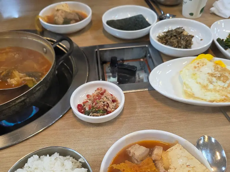 김치찌개와 함께 차려진 다양한 밑반찬과 계란후라이