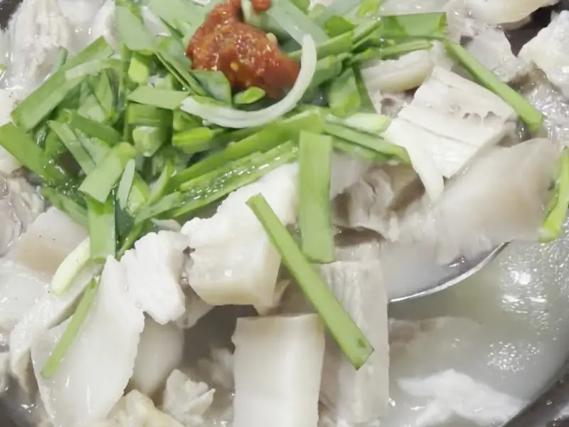 뽀얀 국물 위에 다진 양념과 부추가 올라간 돼지국밥