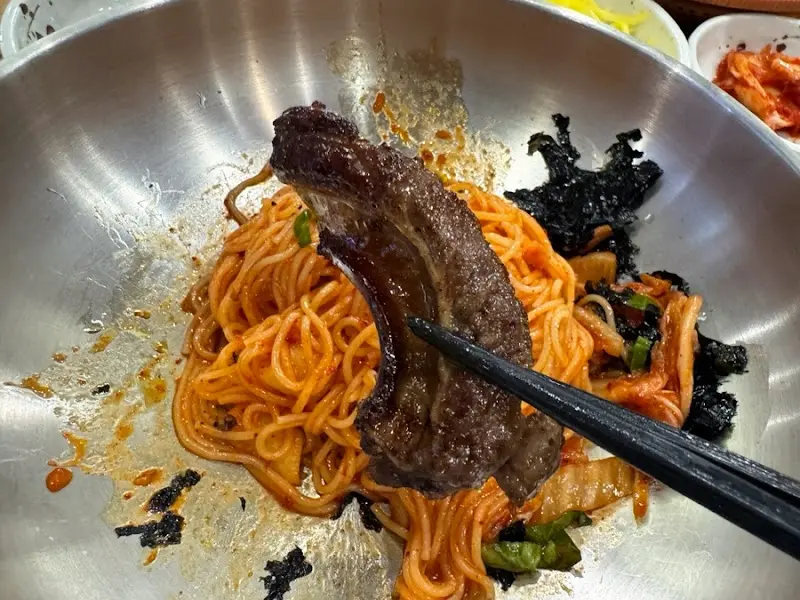 비빔국수에 우대갈비를 올려 먹는 모습