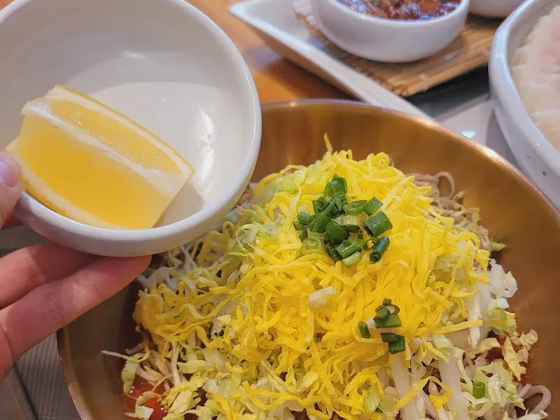 상큼함을 더해주는 레몬 조각이 곁들여진 비빔 막국수
