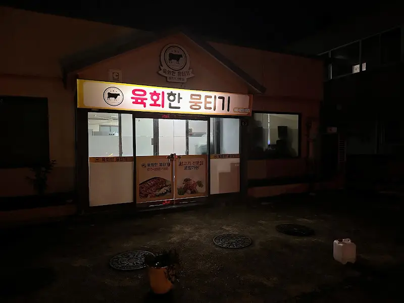 어두운 밤, 빛나는 간판을 자랑하는 육회한뭉티기 가게 전경