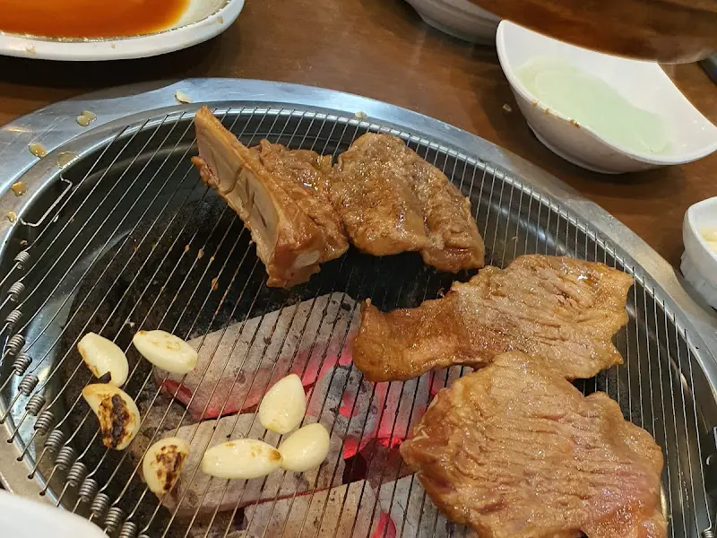 숯불 위에서 익어가는 돼지갈비와 마늘