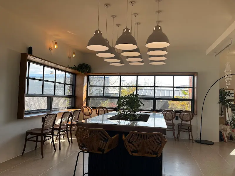 카페 내부, 테이블과 의자가 편안하게 배치되어 있다.