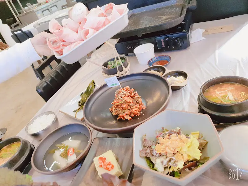 테이블 위에 가득 차려진 우렁쌈밥 한 상