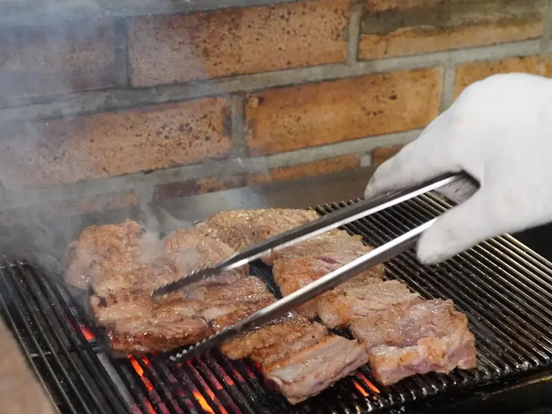 직원이 숯불에 고기를 굽는 모습