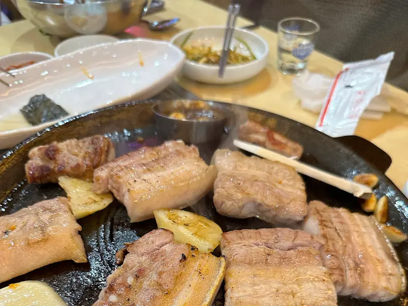 불판 위에 올려진 오겹살과 멜젓의 모습