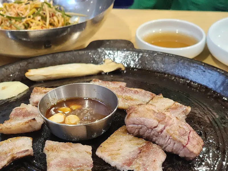 불판 위에 올려진 오겹살과 곁들임 반찬