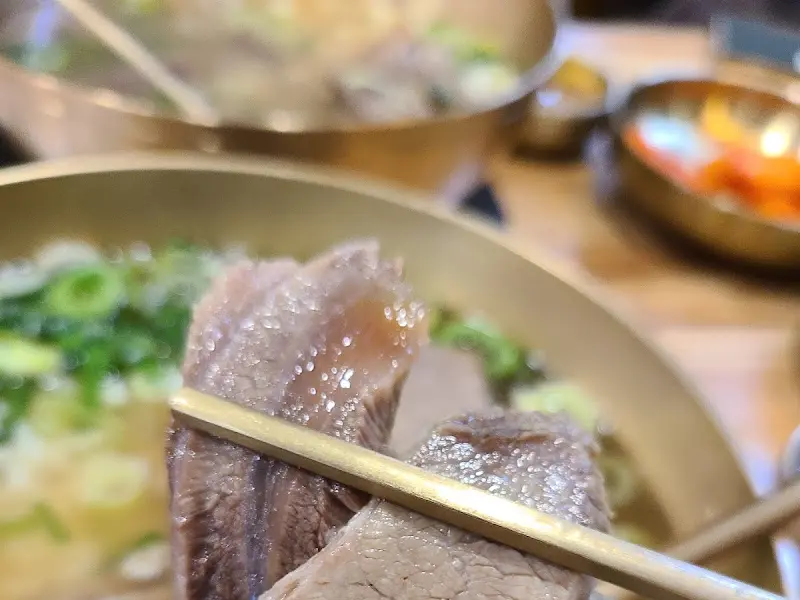 젓가락으로 집어 올린 곰탕 속 살코기