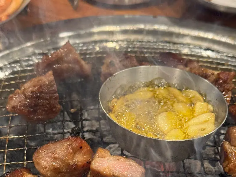 숯불 위에서 구워지고 있는 돼지갈비와 참기름 마늘