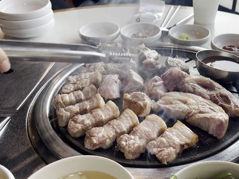 불판 위에서 노릇하게 익어가는 흑돼지