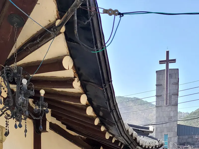 달보다가에서 바라본 풍경, 고즈넉한 한옥 지붕과 멀리 보이는 교회의 조화가 인상적이다.