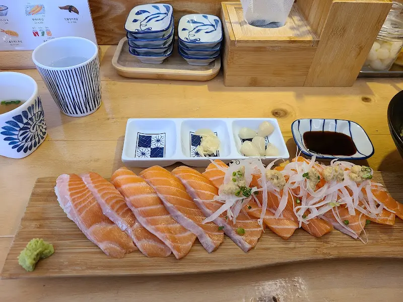 나무 테이블 위에 놓인 연어 초밥 한 상 차림