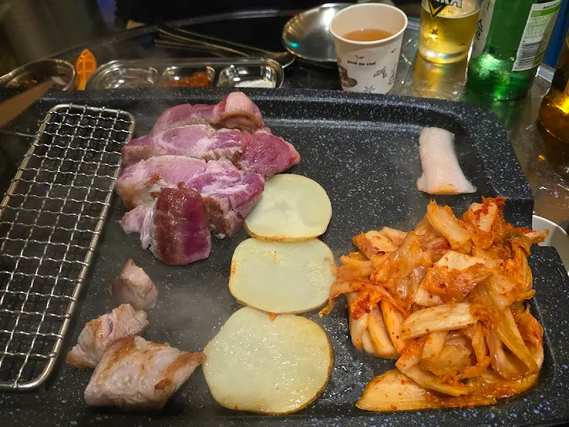 불판 위 삼겹살과 김치, 버섯