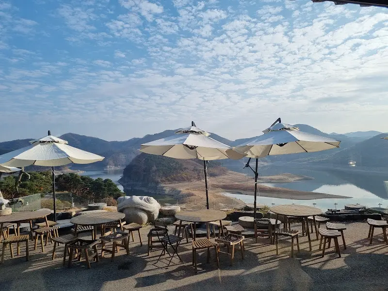 파라솔 아래 테이블에 앉아 옥정호를 감상하는 사람들