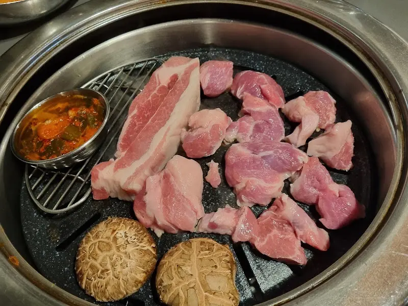 불판 위에 올려진 돼지고기와 버섯