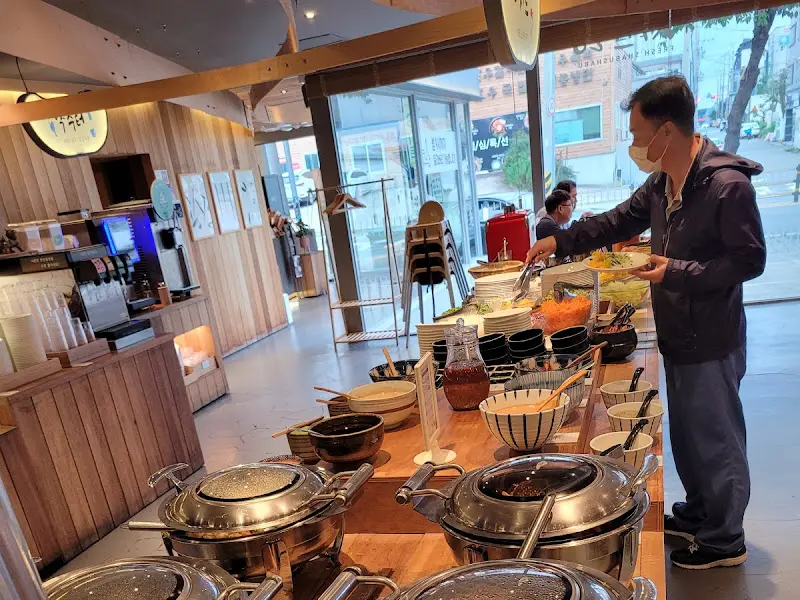 샐러드바에서 음식을 담고 있는 손님의 모습