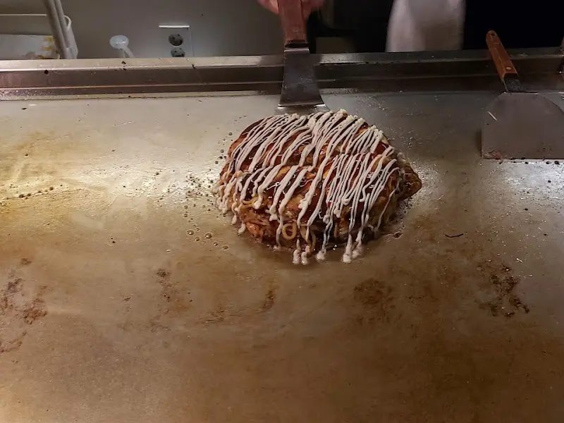 철판 위에서 오코노미야끼가 구워지는 모습