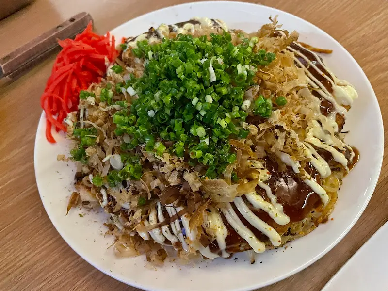 오코노미야끼 위에 마요네즈와 김가루, 가쓰오부시가 듬뿍 뿌려진 모습