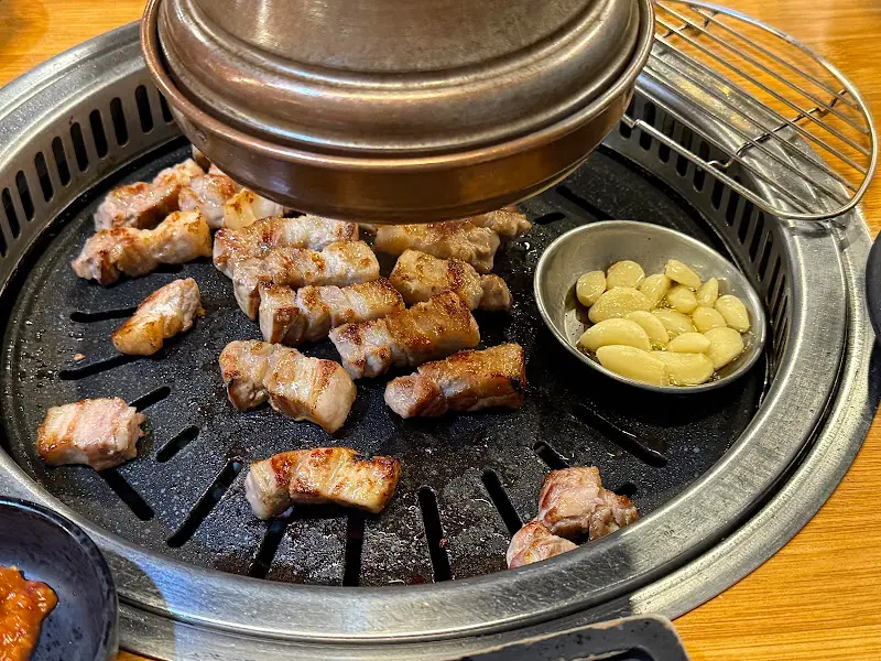 노릇하게 구워진 삼겹살과 마늘