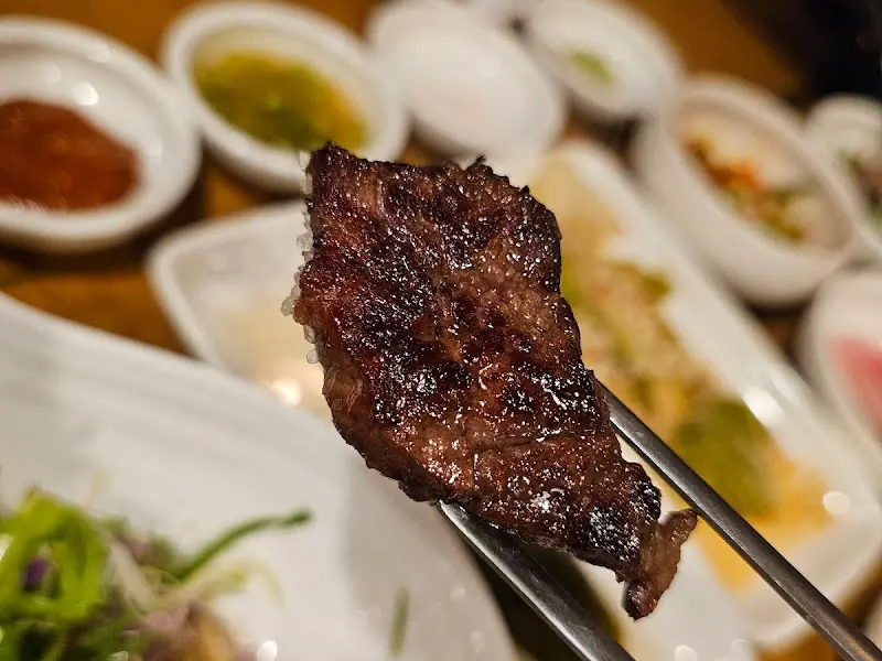 젓가락으로 집어 올린 잘 구워진 소고기