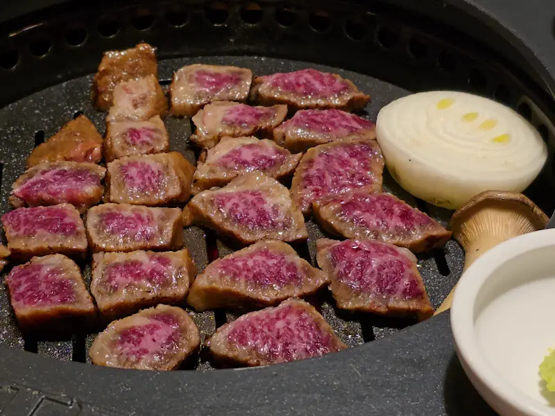 불판 위에 구워진 먹음직스러운 소고기 조각들