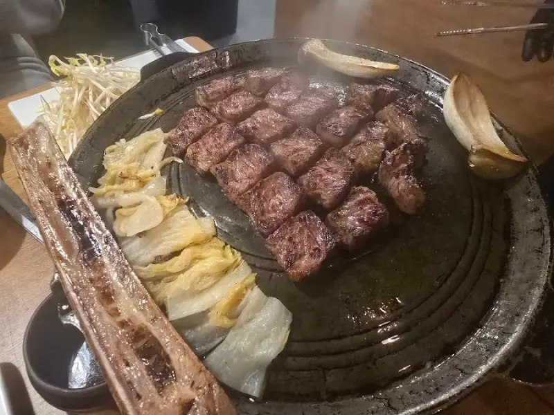 우대갈비와 잘 구워진 소고기가 불판 위에 놓여 있는 모습