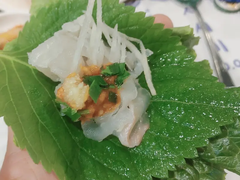 깻잎 위에 회와 무채, 쌈장을 올려 쌈으로 즐기는 모습