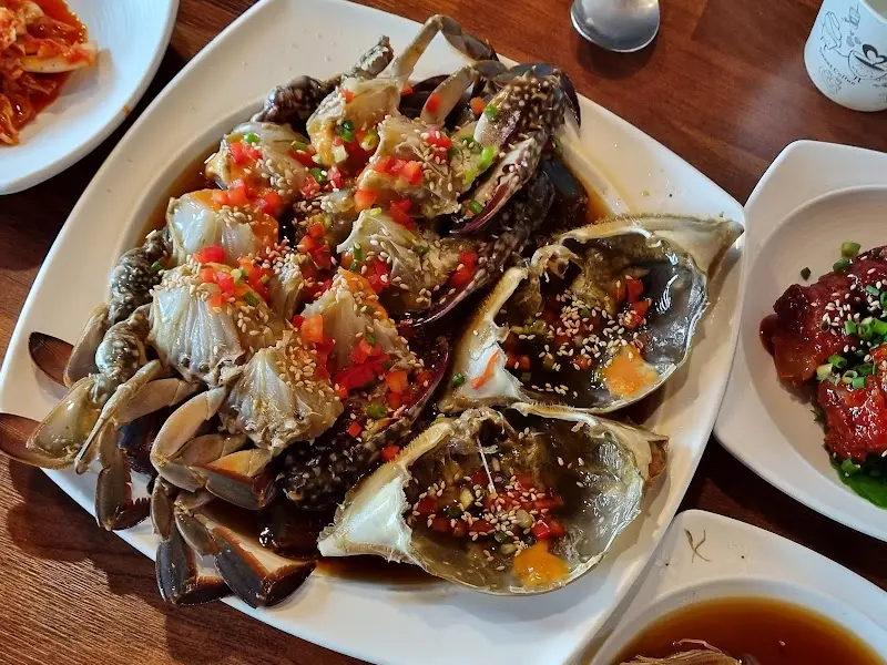 테이블 위에 놓인 간장게장과 김치, 샐러드 사진