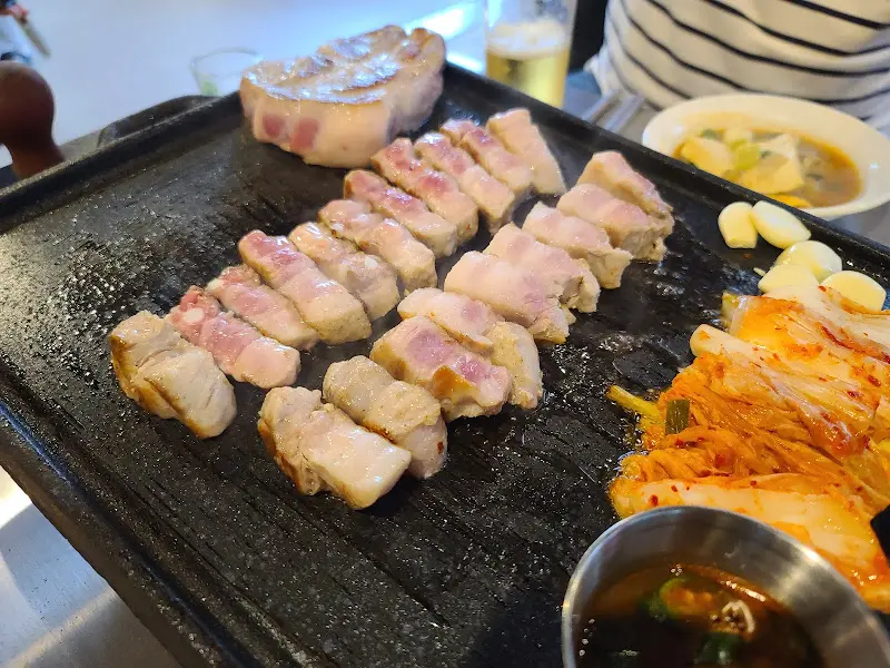 잘 익은 삼겹살이 불판 위에 가지런히 놓여 있는 모습