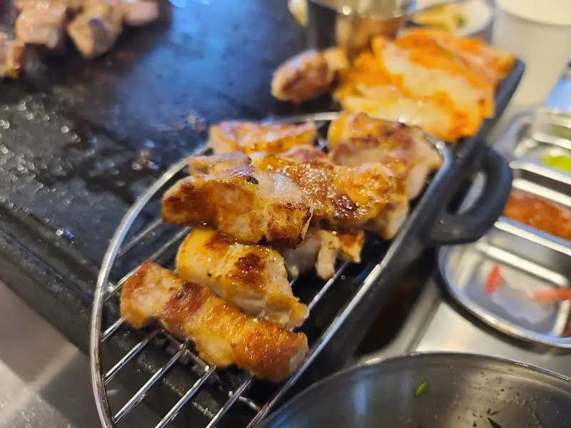 잘 구워진 삼겹살이 철망 위에 올려져 있는 모습