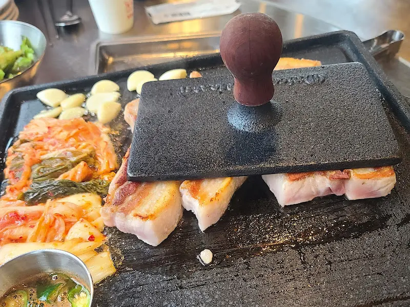 다리미로 삼겹살을 누르는 모습