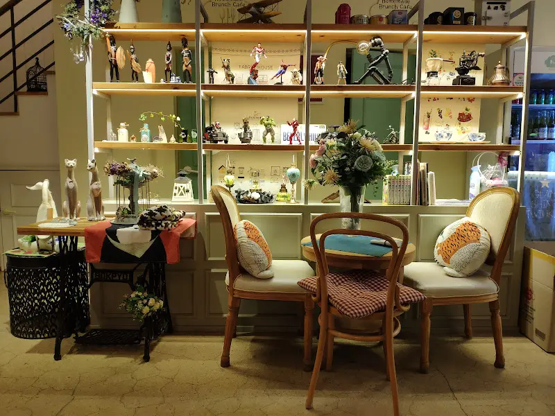 카페 내부 인테리어 사진. 테이블, 의자, 책장, 소품 등이 보인다.