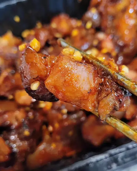 젓가락으로 집어 올린 양념 족발 한 점