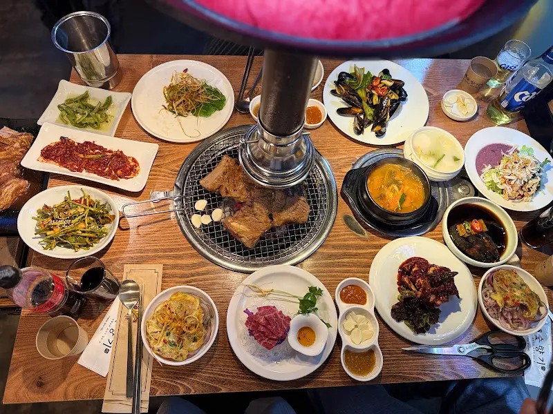 테이블 가득 차려진 밑반찬과 고기