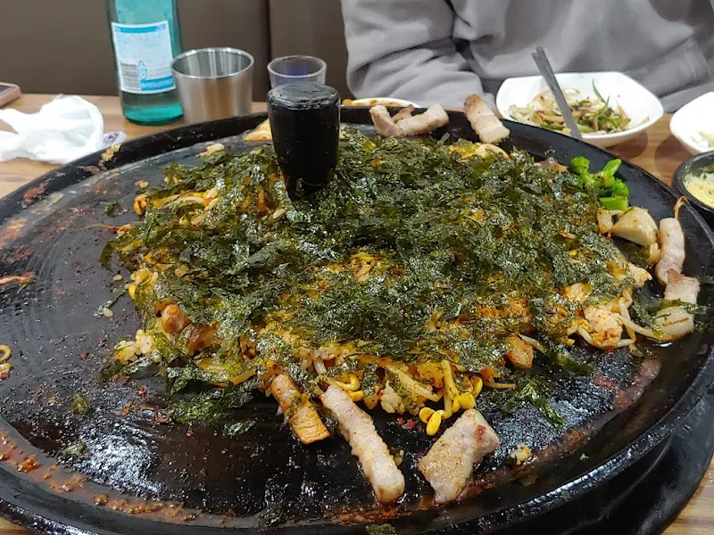 솥뚜껑 볶음밥 위에 김가루가 뿌려진 모습