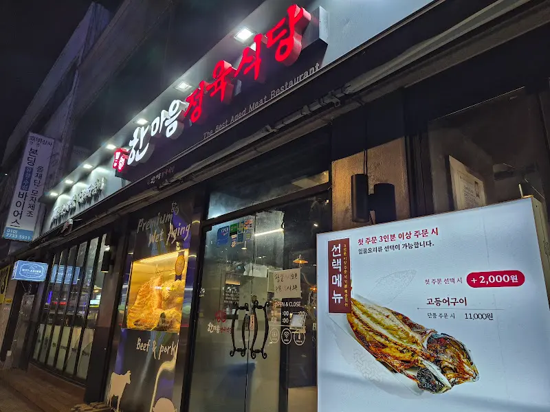 붉은색 네온사인 간판이 인상적인 식당 외관