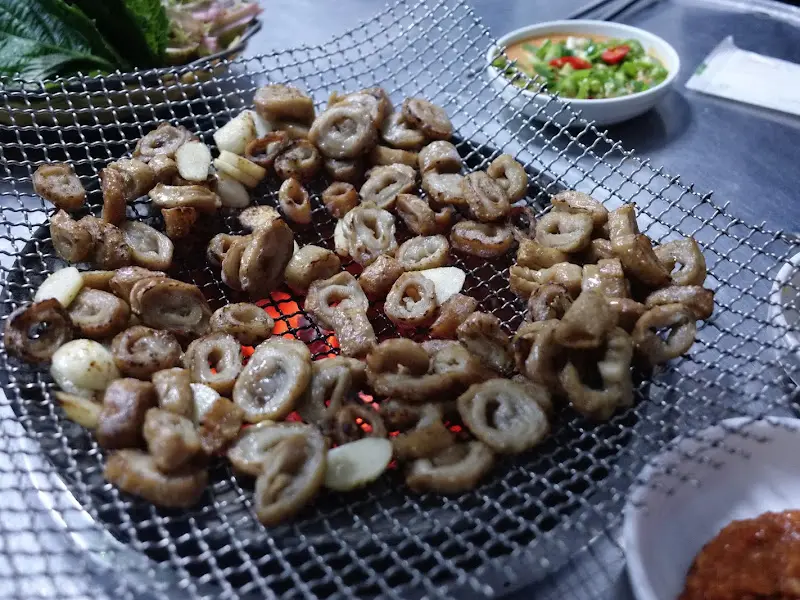 숯불 위에서 막창과 마늘이 함께 구워지는 모습