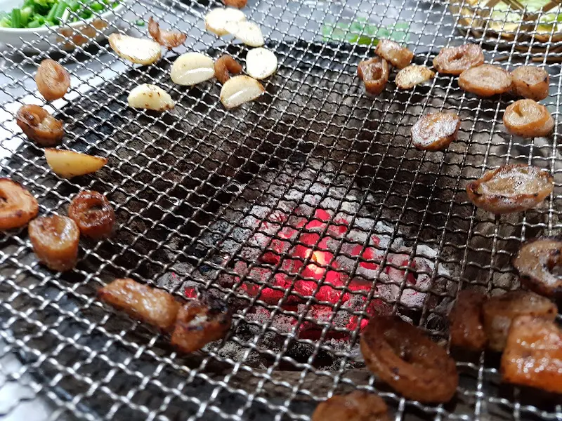 숯불 위에 구워지는 막창과 마늘