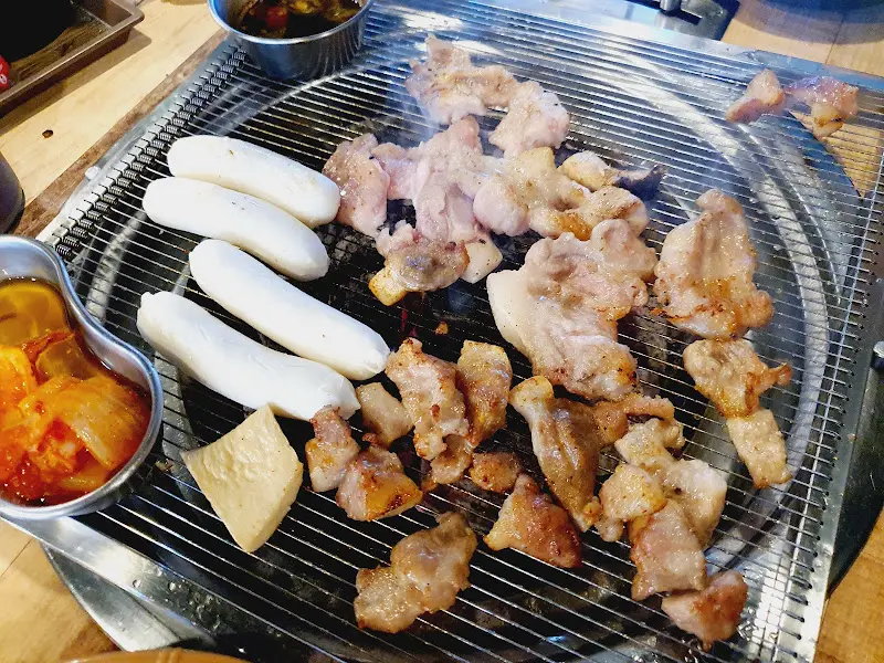 불판 위에서 익어가는 꼬들목살과 치즈떡