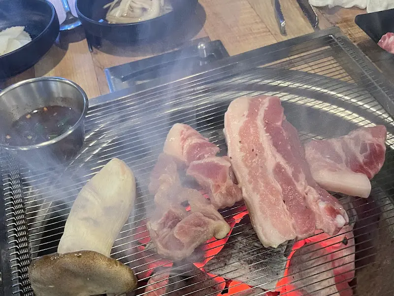 연기가 피어오르는 불판 위의 고기