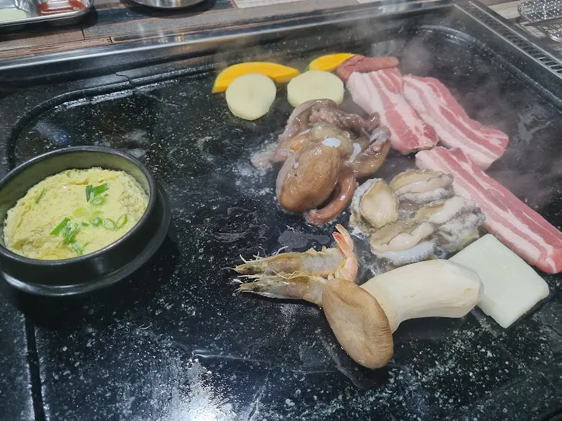 돌판 위에서 익어가는 해물과 삼겹살