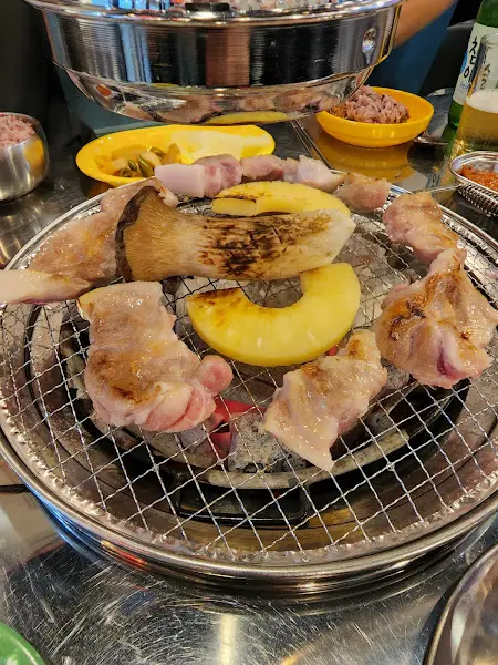 불판 위에 구워지는 삼겹살과 곁들임