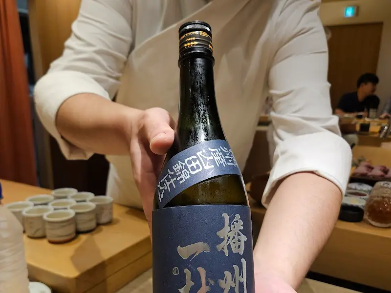 셰프가 사케병을 들고 있는 모습