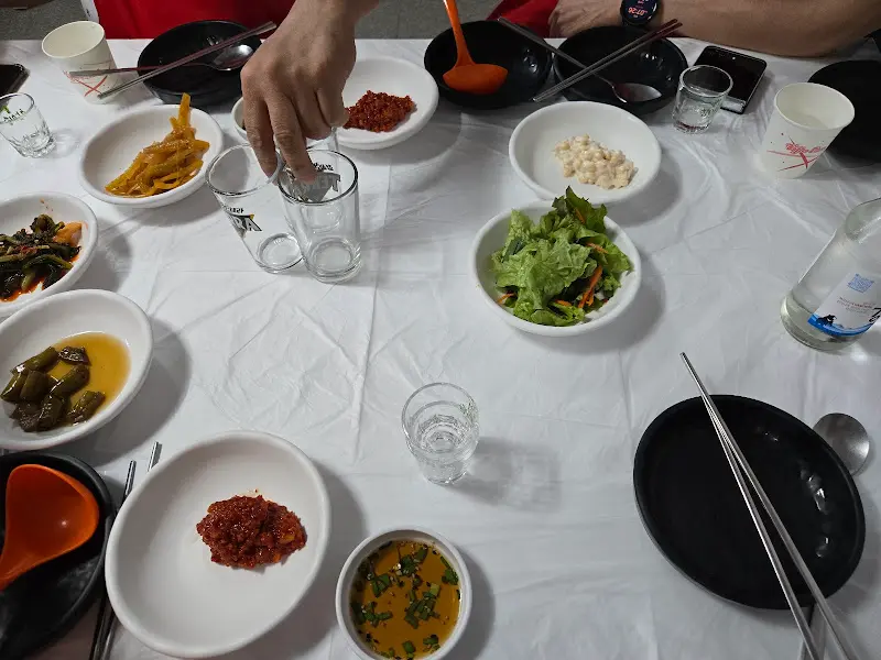 소주잔에 술을 따르는 모습과 밑반찬