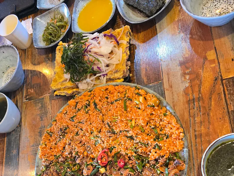 테이블 위에 놓인 꼬막 비빔밥과 육전, 밑반찬들의 모습